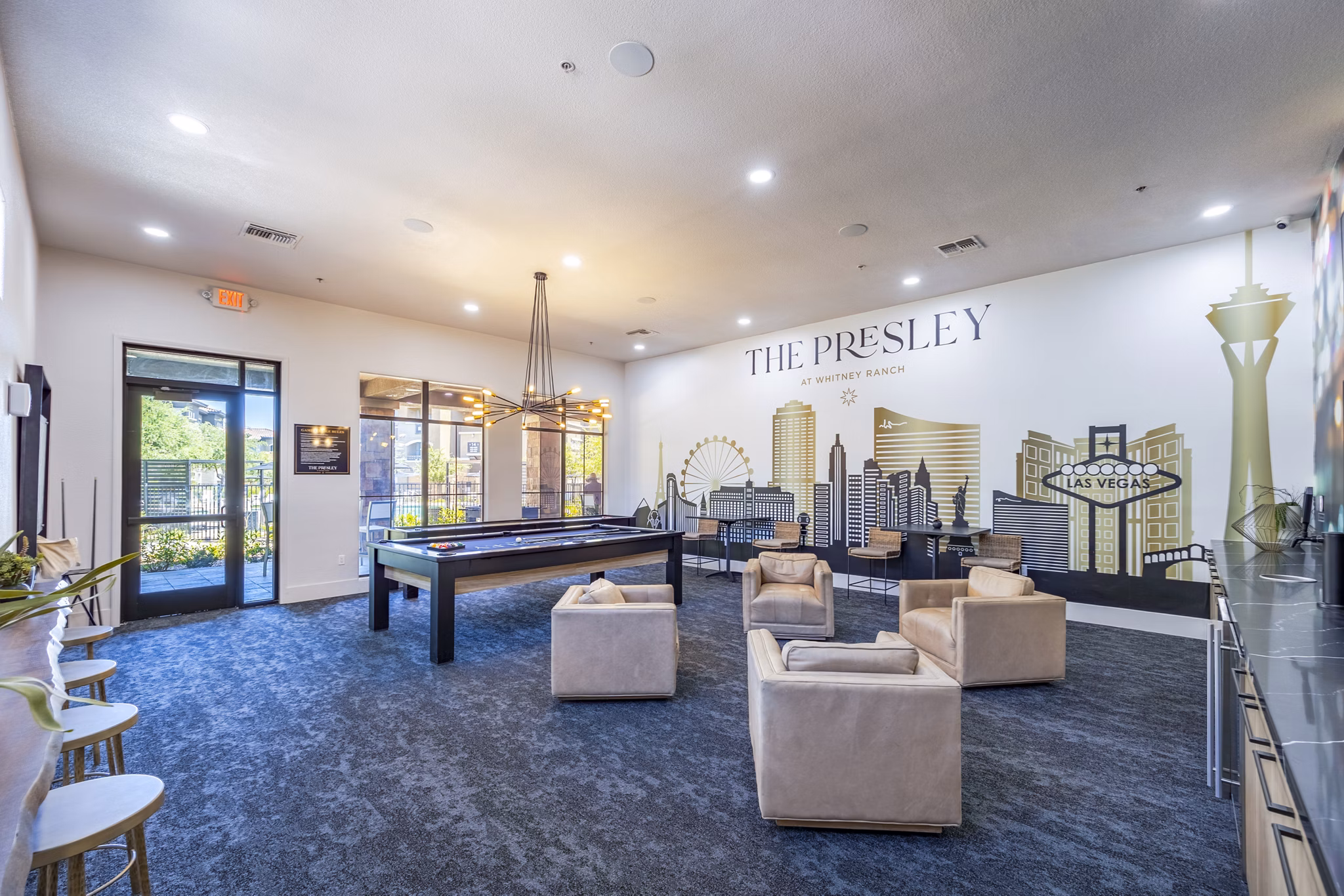 Clubhouse game room featuring pool table and lounge seating at The Presley at Whitney Ranch Apartments, a Greystar luxury property