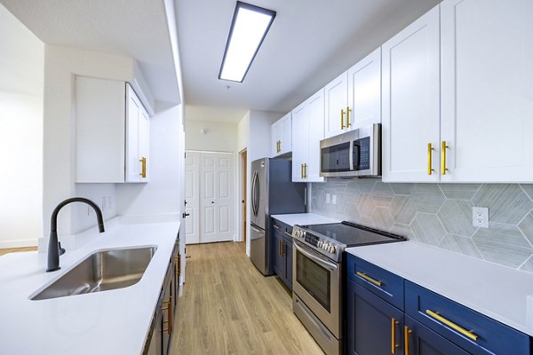 Modern kitchen featuring stainless steel appliances and granite countertops in The Presley at Whitney Ranch Homes