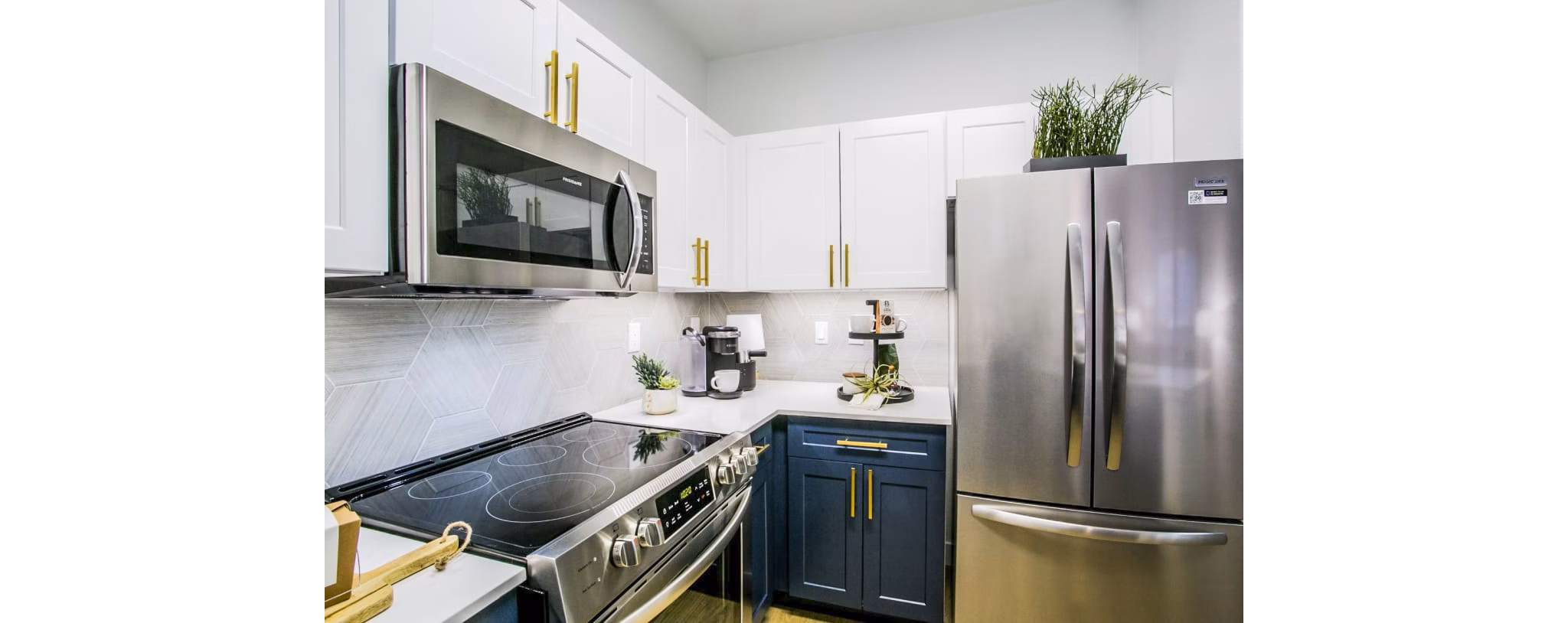 Modern kitchen with stainless steel appliances in The Presley at Whitney Ranch Homes apartments
