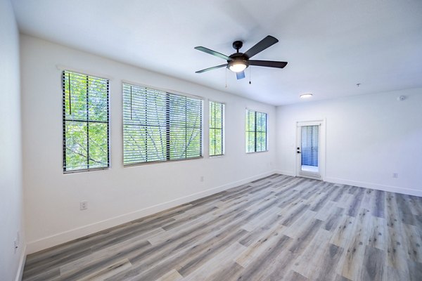 Spacious living room with modern decor in The Presley at Whitney Ranch Apartments