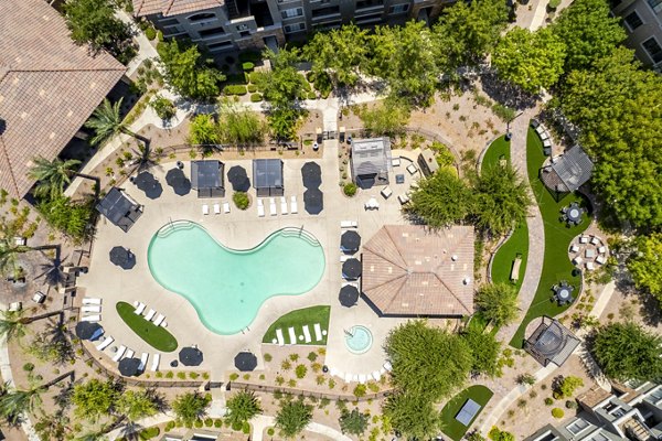 Resort-style pool at The Presley at Whitney Ranch Apartments with poolside seating for luxury relaxation