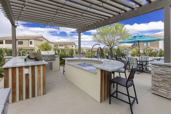 Outdoor grill area at Townhomes at Horizon Ridge Apartments offering modern seating and lush landscaping for resident gatherings