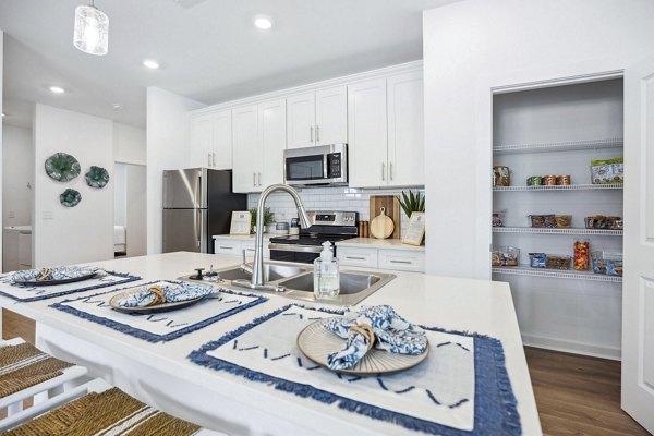 Contemporary kitchen with modern appliances at River Rock at Blume Road Apartment Homes