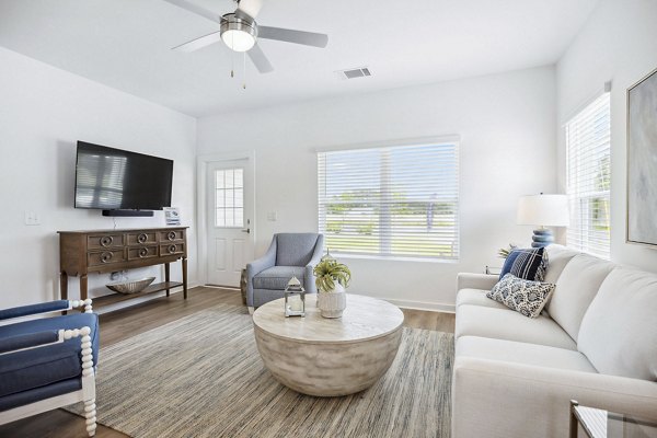 Living room featuring cozy seating and modern decor at River Rock at Blume Road Apartment Homes