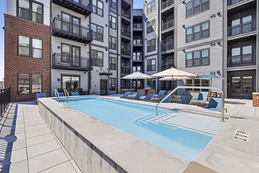Infinity-edge pool at The Navigator Apartments with luxurious seating and scenic views