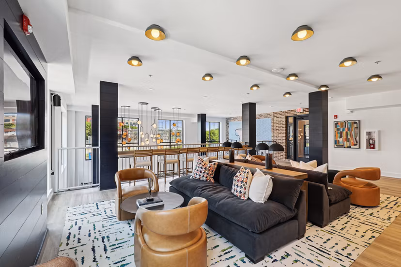 Clubhouse with modern seating and game area at The Navigator Apartments