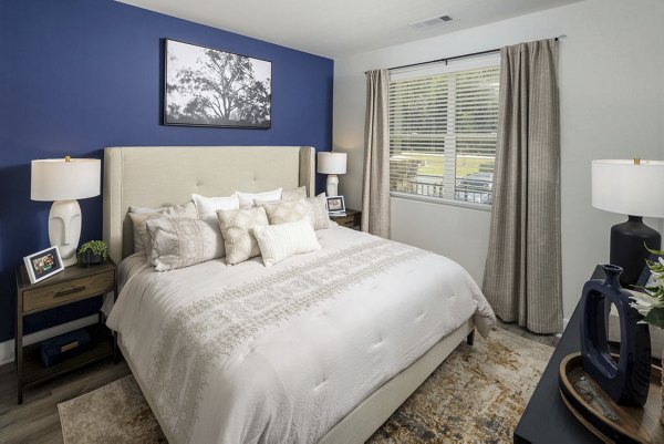 Cozy bedroom with modern accents at Bell's Lake Apartments, offering luxury living and relaxing ambiance for residents