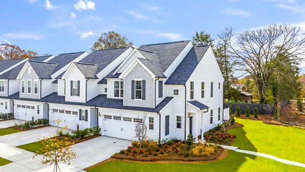 Modern townhouses with garages nestled in landscaped lawns and trees
