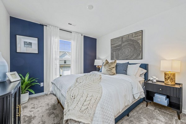 Cozy bedroom with modern furnishings at Wayford at Pringle Towns Apartments