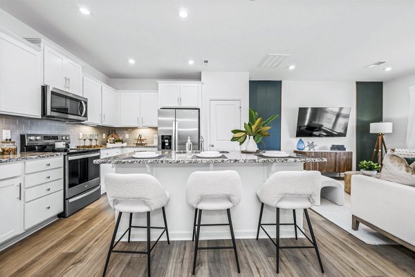 Wayford at Pringle Towns: Modern kitchen with stainless steel appliances and granite countertops in luxury apartment
