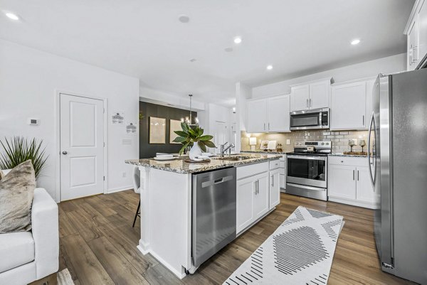 Contemporary kitchen with stainless steel appliances and granite countertops at Wayford at Pringle Towns Apartments