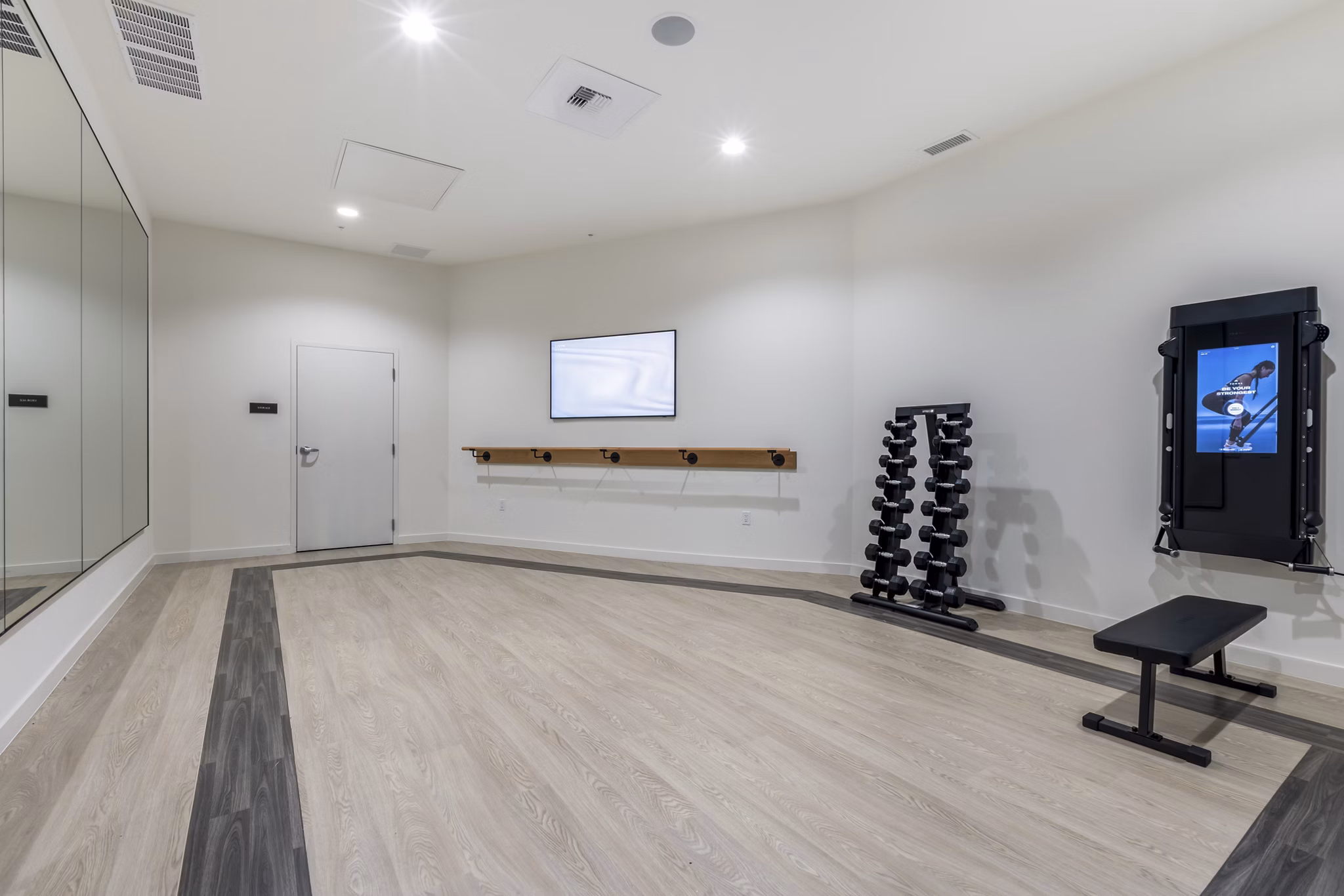 Modern yoga/spin studio with mirrored walls at Broadstone Savoie Apartments