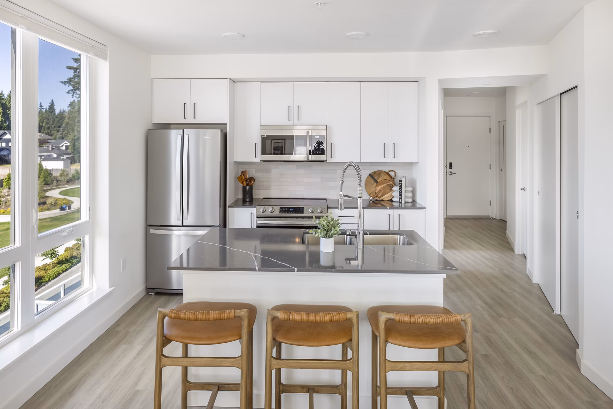 Modern kitchen with stainless steel appliances and granite countertops at Broadstone Savoie Apartments luxury homes