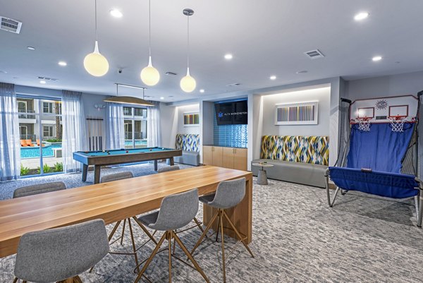 Clubhouse game room with billiards and lounge seating at Alta Washington Apartments