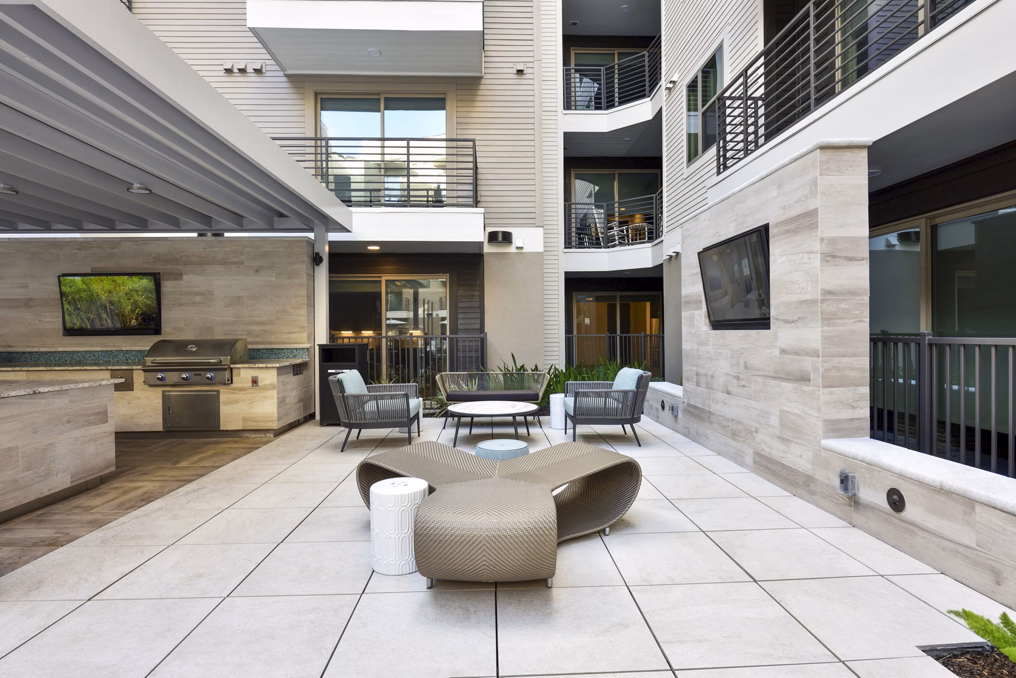 Grill area with modern patio seating at Crosstown Phoenix East Apartments, perfect for outdoor gatherings and relaxation