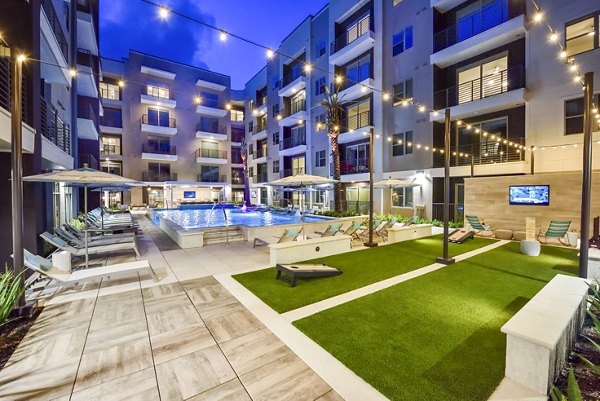 Outdoor pool and recreational area with lounge seating at Alta Washington Apartments, ideal for relaxation and socializing