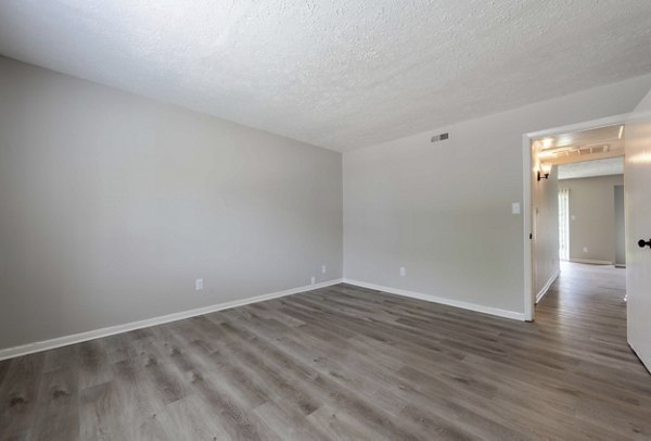 Spacious living room with modern decor and ample natural light in The Retreat Northwest Apartments