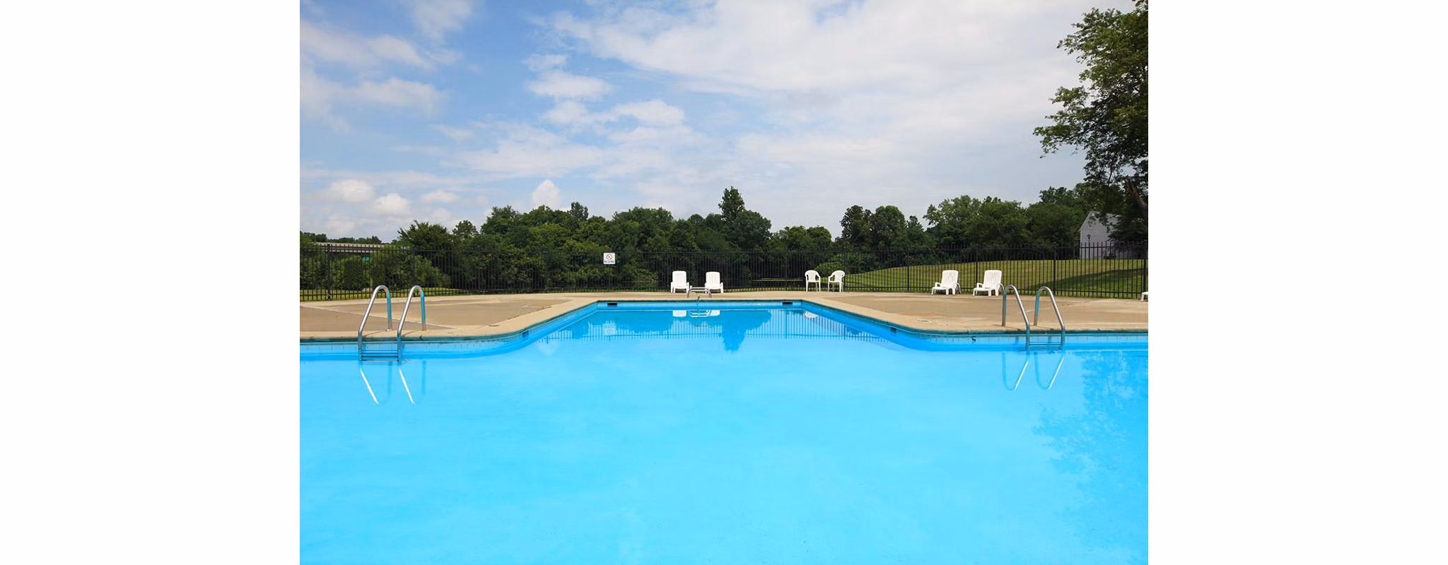 Resort-style pool with lounge chairs at The Retreat Northwest Apartments, offering relaxation and leisure