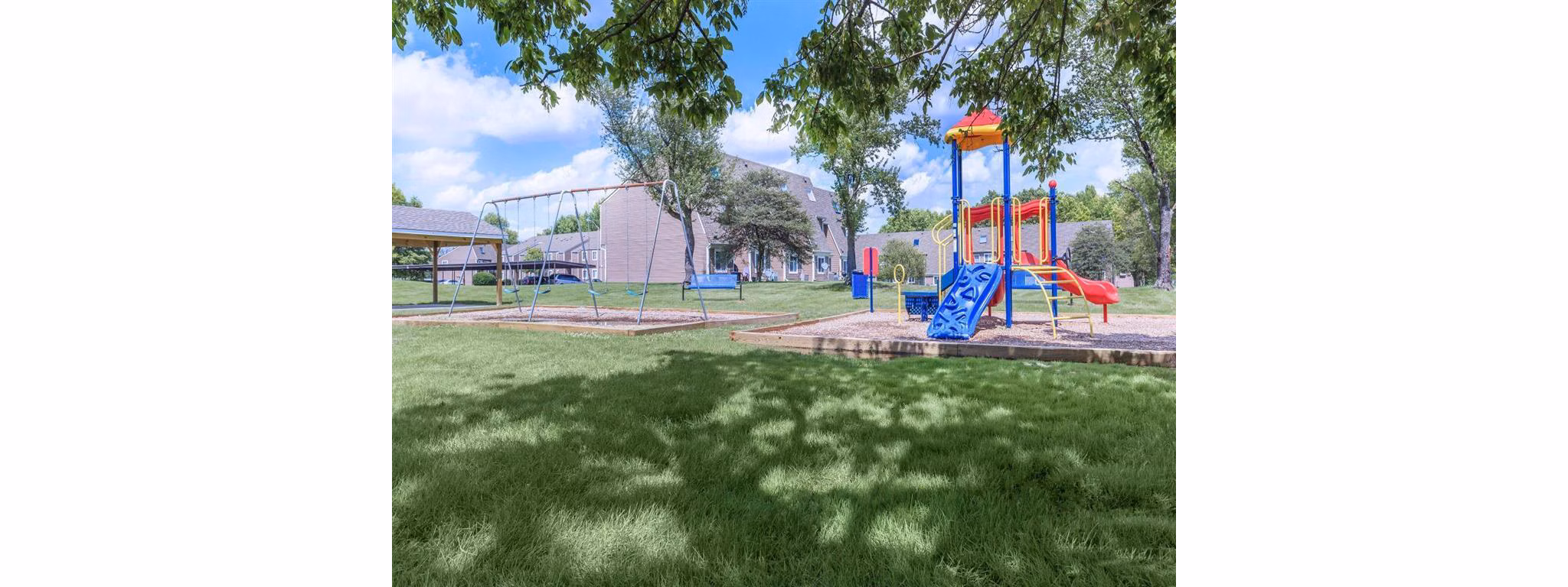 Modern playground with swings and slides at The Retreat Northwest Apartments, perfect for family-friendly outdoor recreation
