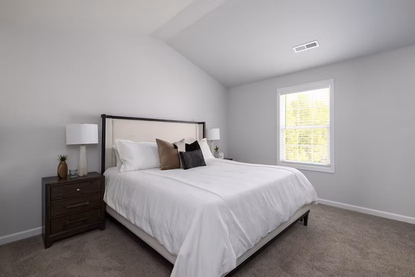Bedroom with modern furniture and natural light at Smith Crossing Apartments