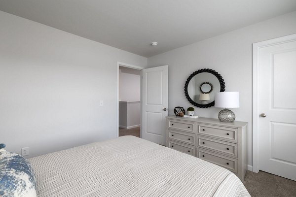 Smith Crossing Apartments: Modern bedroom with luxurious decor and ample natural light