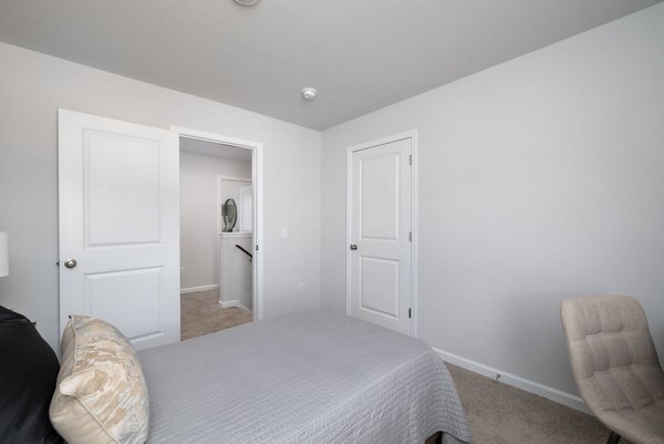 Cozy bedroom with modern decor and large window at Smith Crossing Apartments, offering luxury apartment living in a serene setting