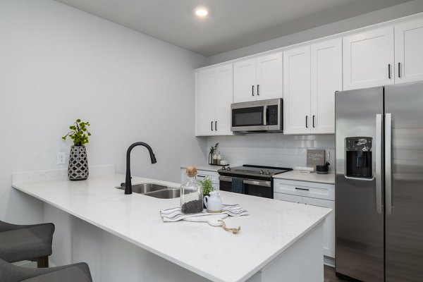 Kitchen with modern appliances and sleek countertops in Spire at Smith Crossing Apartments
