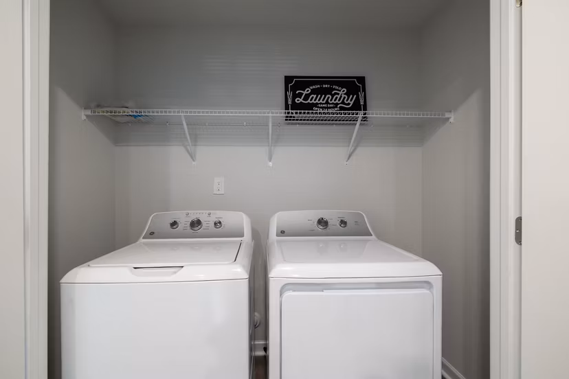Modern laundry room with high-efficiency washers and dryers at Spire at Smith Crossing Apartments