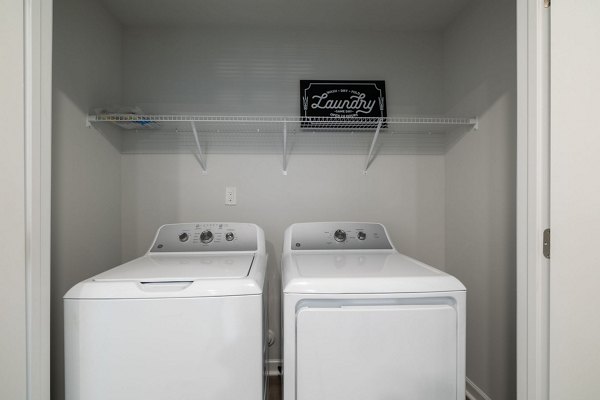 Modern laundry room with high-efficiency washers and dryers at Spire at Smith Crossing Apartments