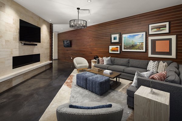 Modern living room with sectional sofa, fireplace, and framed artwork in luxury apartment