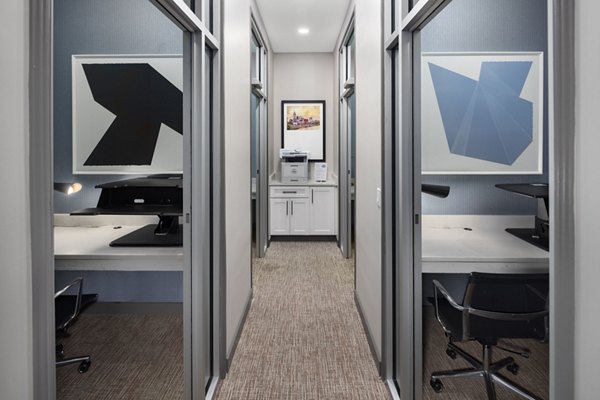 Modern office space featuring dual workstations with desks and monitors, complemented by abstract art on the walls