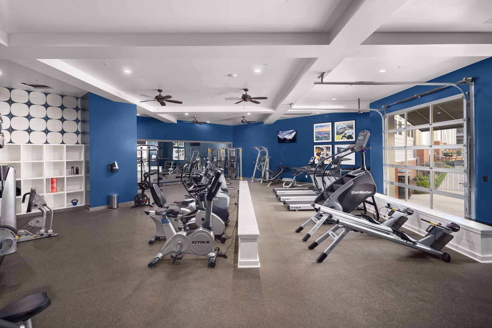 Well-equipped fitness center with exercise machines at luxury apartments