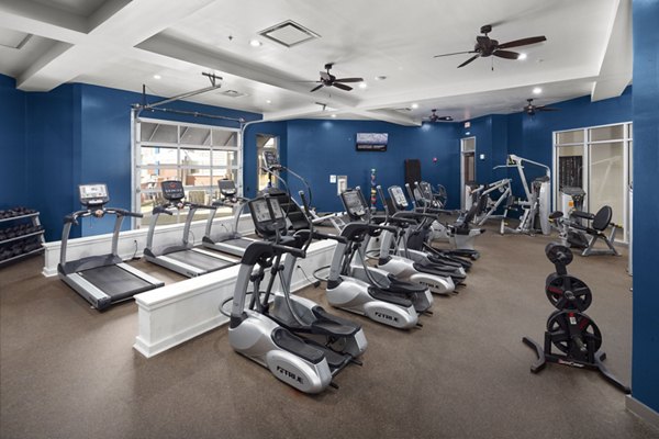 Modern gym featuring treadmills, ellipticals, and weight machines in luxury apartment community