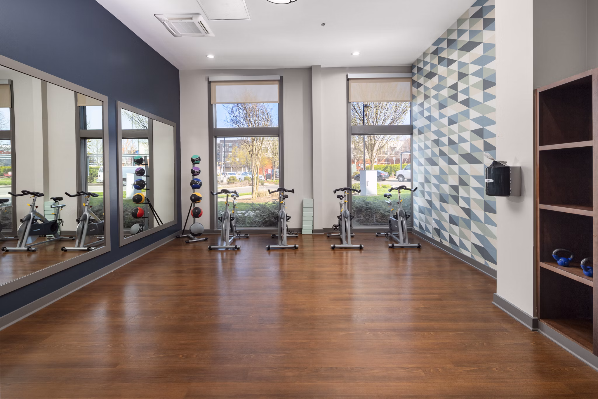 Modern fitness room with exercise bikes and medicine balls in luxury apartments