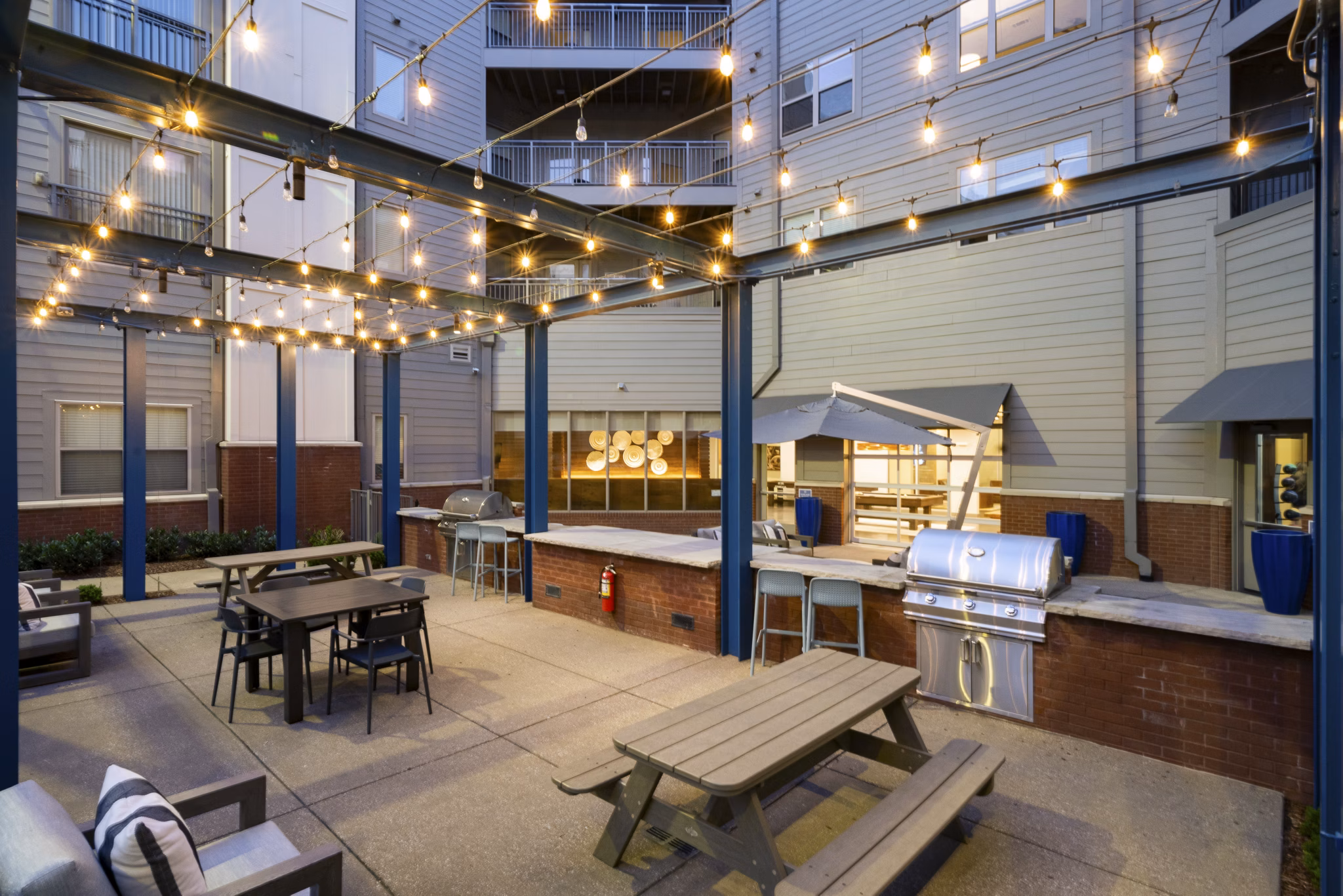 Outdoor patio area with string lights and grill station at luxury apartments