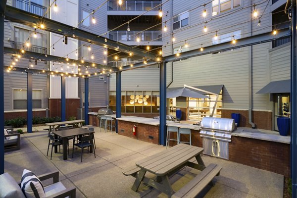 Outdoor patio area with string lights and grill station at luxury apartments