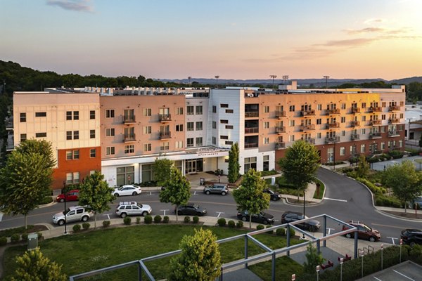 Modern multi-story luxury apartments with landscaped surroundings and parking area in upscale neighborhood