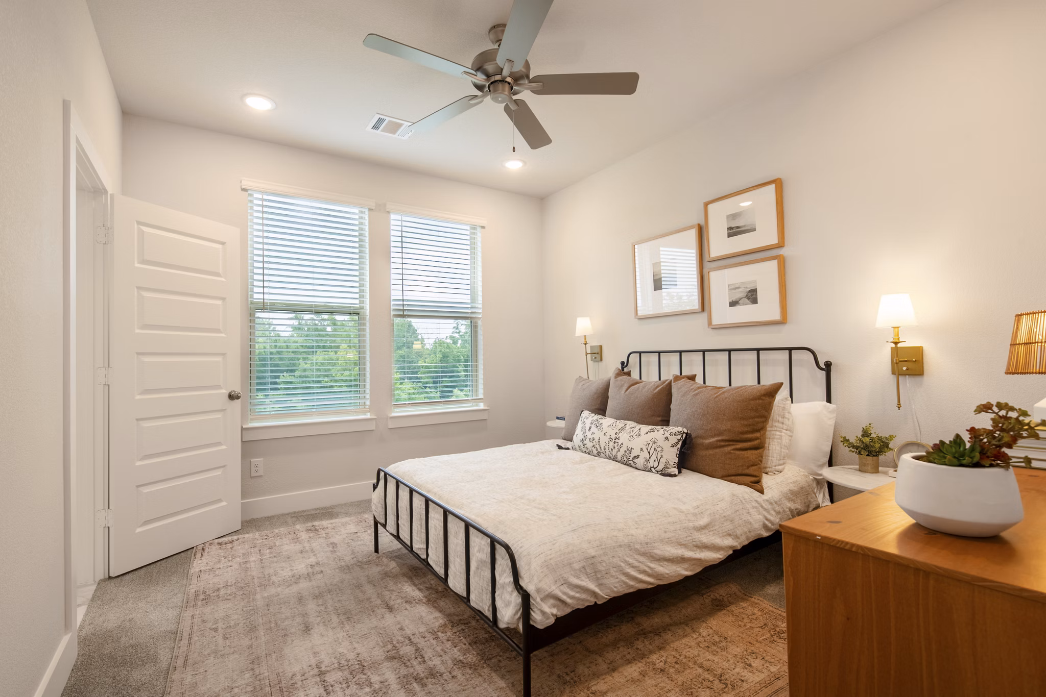 Cozy bedroom with modern decor in Mission at Johnson Creek Apartments, featuring ample natural light for a relaxing ambiance
