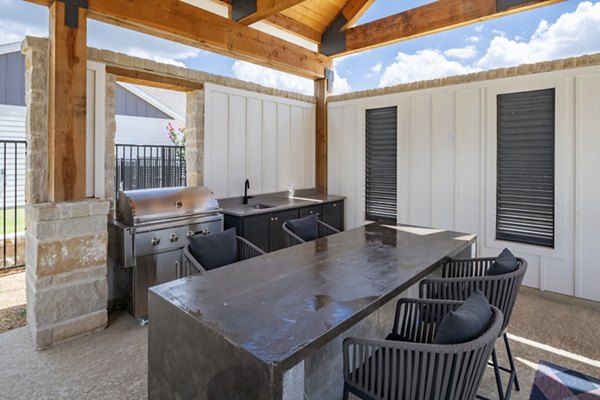 Outdoor grill area with modern seating at Mission at Johnson Creek Apartments, ideal for social gatherings and entertainment