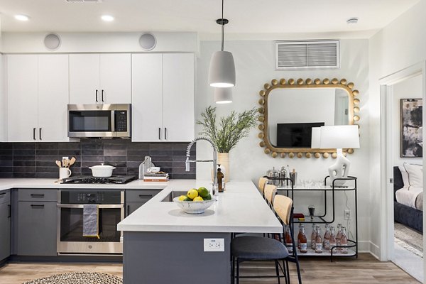 Modern kitchen with sleek granite countertops and stainless steel appliances in Broadstone Uptown Apartments