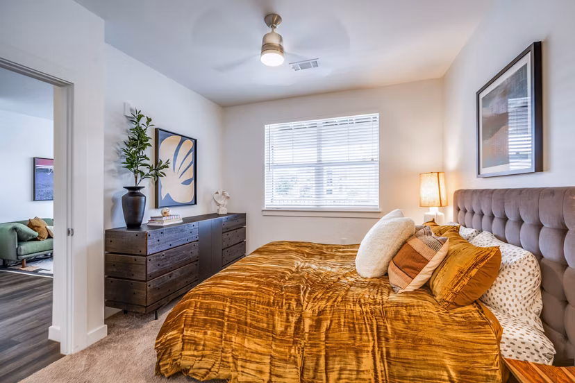 Cozy bedroom with contemporary decor at Lariat Apartments, featuring plush bedding and ample natural light
