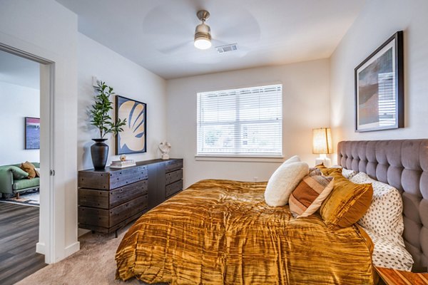 Cozy bedroom with contemporary decor at Lariat Apartments, featuring plush bedding and ample natural light