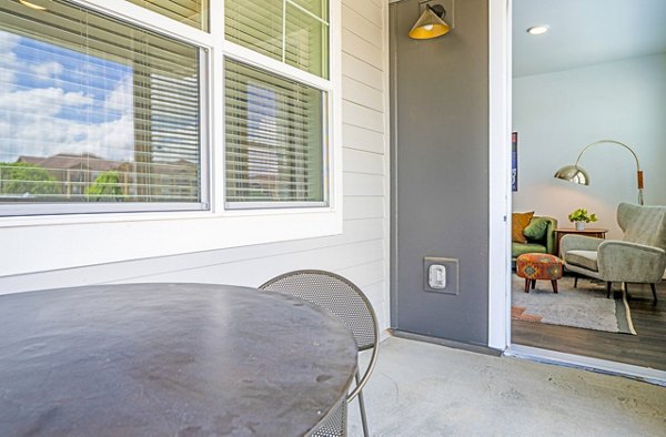 Lariat Apartments: Cozy patio/balcony with modern seating and lush foliage