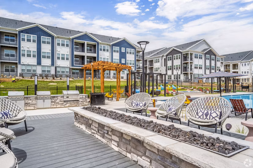 Outdoor grill area with fire pit on patio at Lariat Apartments