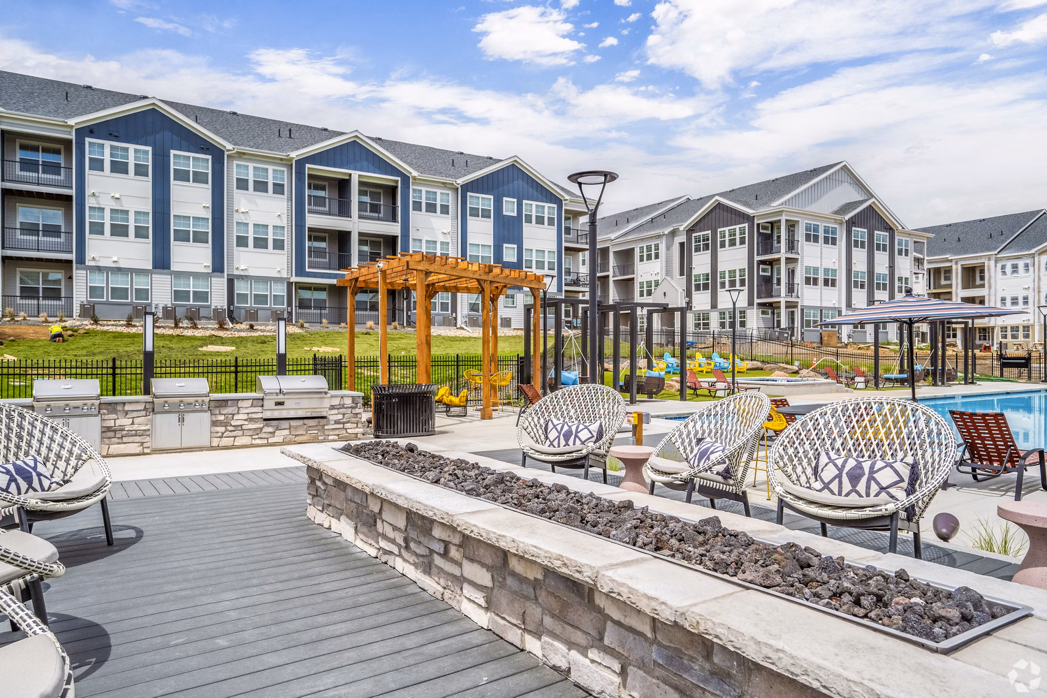 Outdoor grill area with fire pit on patio at Lariat Apartments