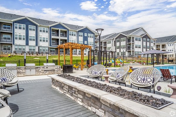 Outdoor grill area with fire pit on patio at Lariat Apartments