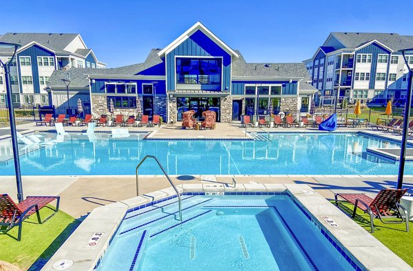 Pool area with lounge chairs and palm trees at Lariat Apartments, luxury Greystar community