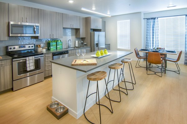 Modern kitchen with stainless steel appliances and granite countertops at Railway Flats Apartments