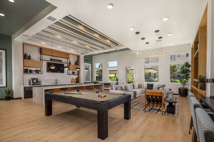 Clubhouse game room at Delhaven Pointe Apartments featuring pool table and lounge seating