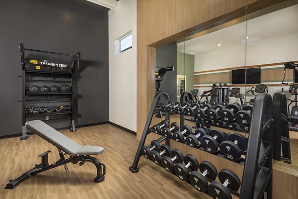 Modern fitness center at Delhaven Pointe Apartments featuring state-of-the-art equipment and spacious workout area for residents